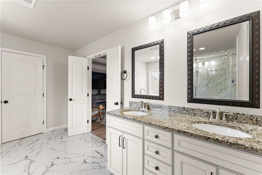 6667 Rivergreen Road Flowery Branch, GA 30542 - Photo 26 of 50 a bathroom with a granite countertop sink and a mirror