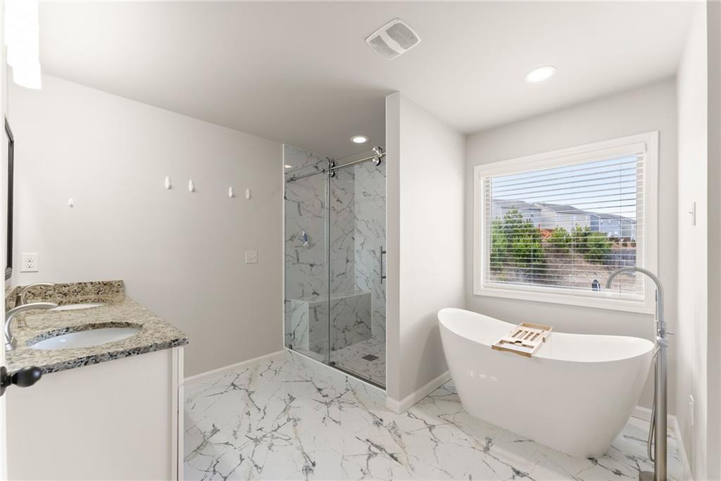 6667 Rivergreen Road Flowery Branch, GA 30542 - Photo 27 of 50 a bathroom with a granite countertop sink a toilet a shower and a bathtub
