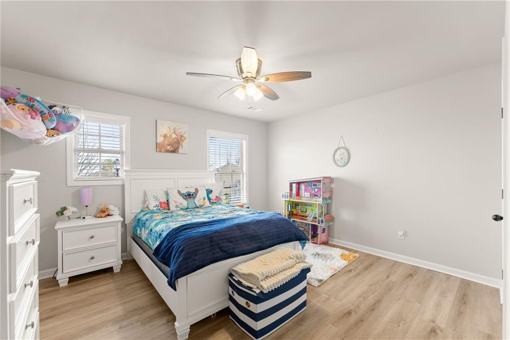 6667 Rivergreen Road Flowery Branch, GA 30542 - Photo 36 of 50 a bedroom with a bed and a chandelier