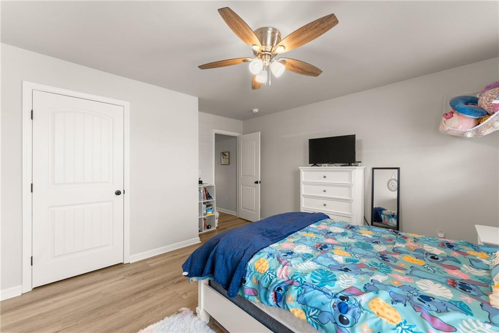 6667 Rivergreen Road Flowery Branch, GA 30542 - Photo 37 of 50 a bedroom with a bed and a tv on the dresser