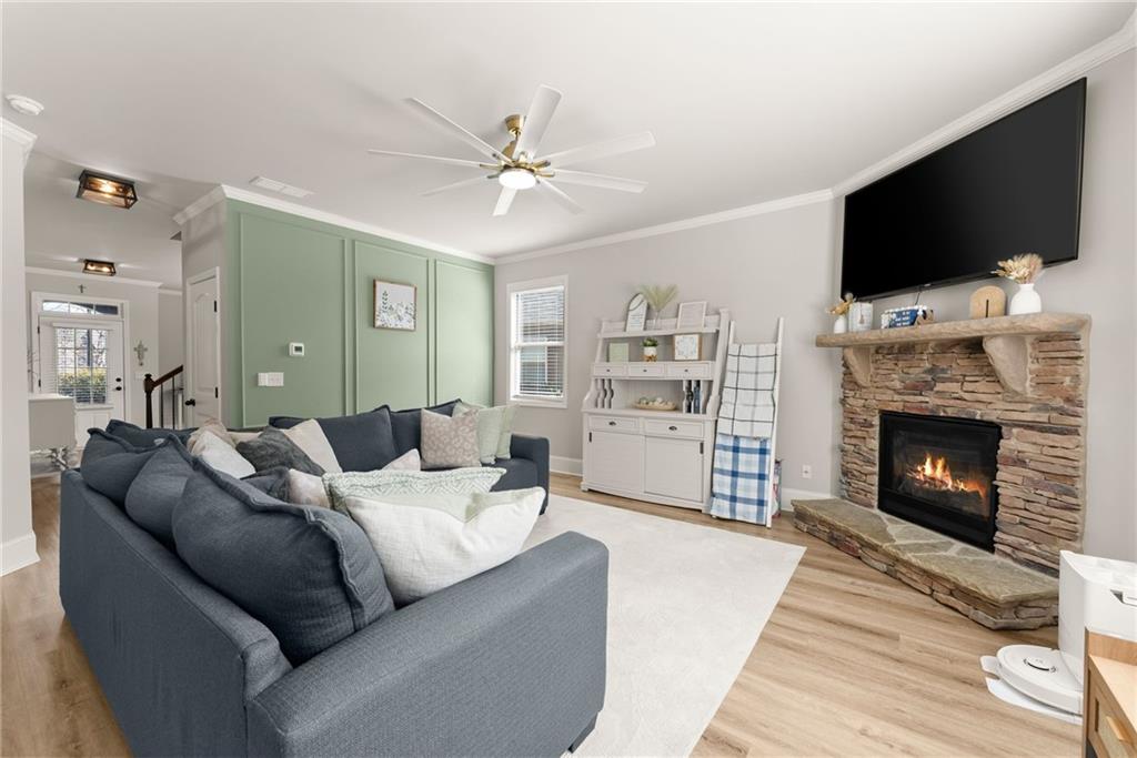 6667 Rivergreen Road Flowery Branch, GA 30542 - Photo 9 of 50 a living room with furniture a flat screen tv and a fireplace