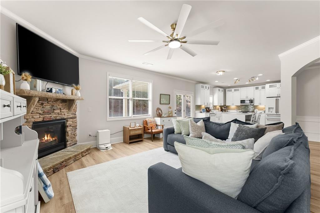 6667 Rivergreen Road Flowery Branch, GA 30542 - Photo 10 of 50 a living room with furniture a flat screen tv and a fireplace