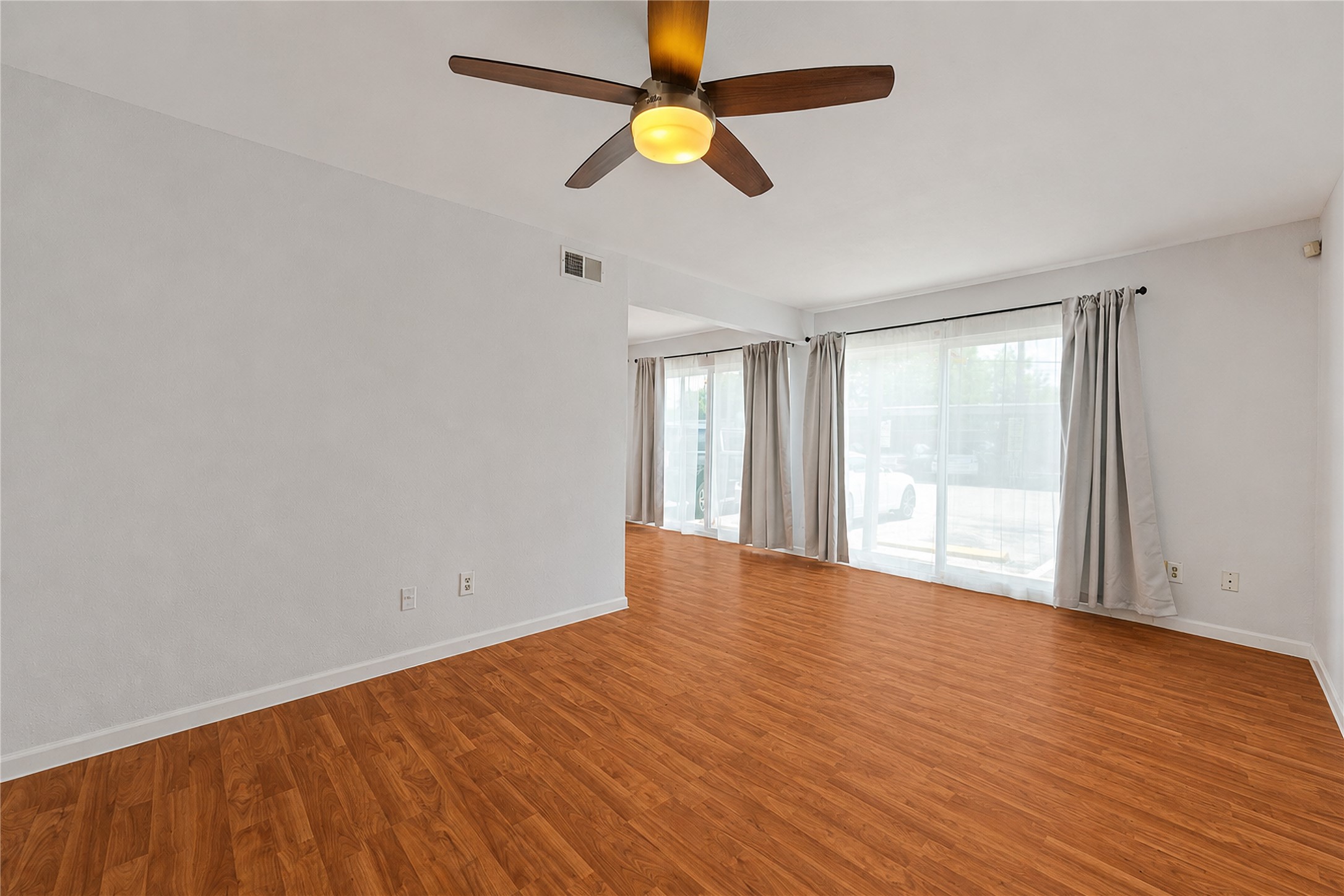 2124 Burton Drive, Unit 159 Austin, TX 78741 - Photo 5 of 23 Naturally illuminated living space featuring rich hardwood flooring and a stylish ceiling fan for comfort.