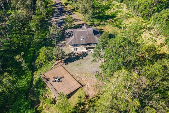 an aerial view of a house with a yard and lake view