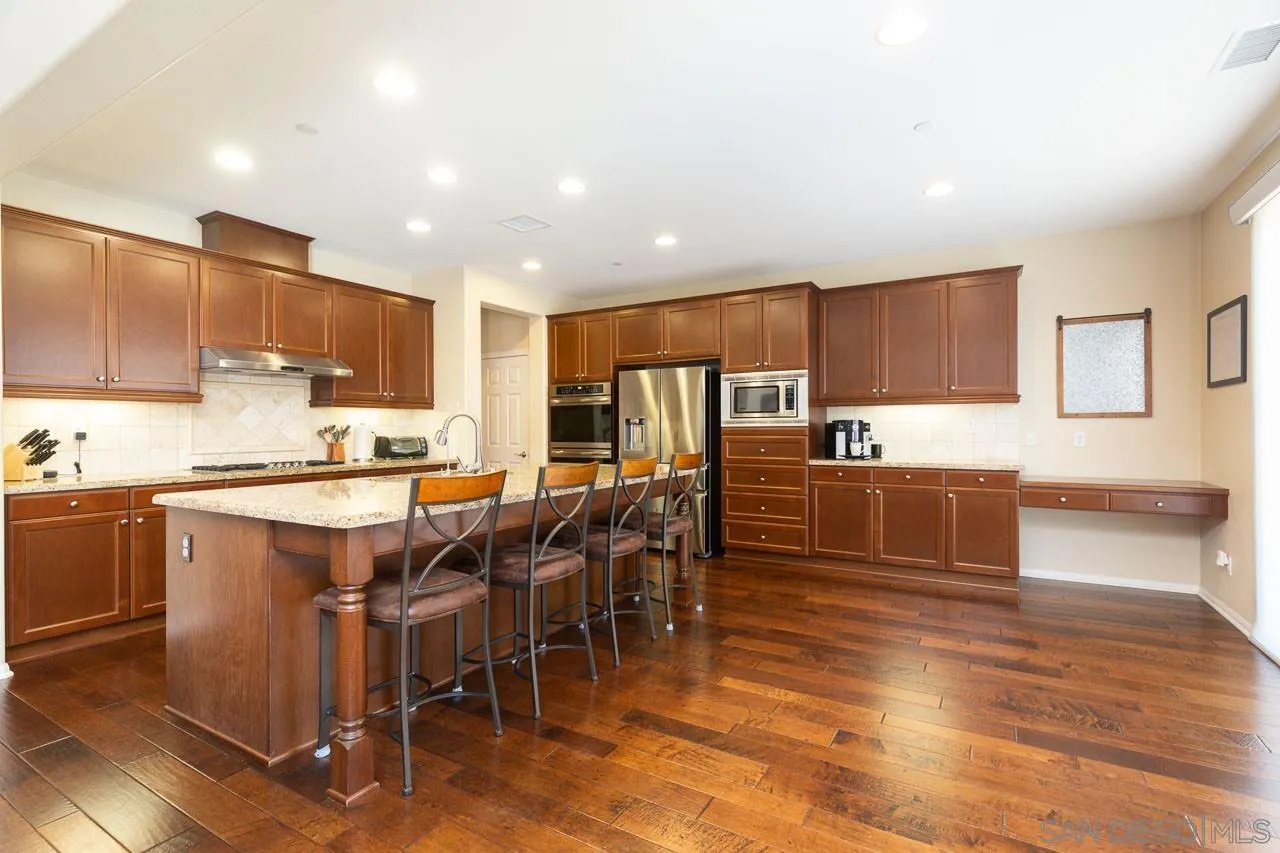 17662 Ralphs Ranch Road San Diego, CA 92127 - Photo 4 of 27 a large kitchen with lots of counter space wooden floor and stainless steel appliances