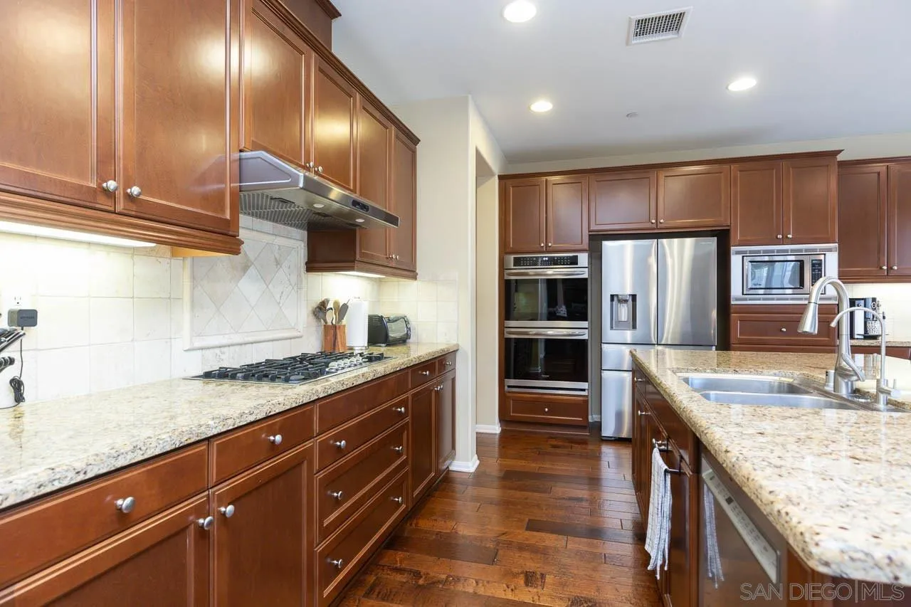 17662 Ralphs Ranch Road San Diego, CA 92127 - Photo 5 of 27 a kitchen with stainless steel appliances granite countertop a sink a stove counter space and cabinets