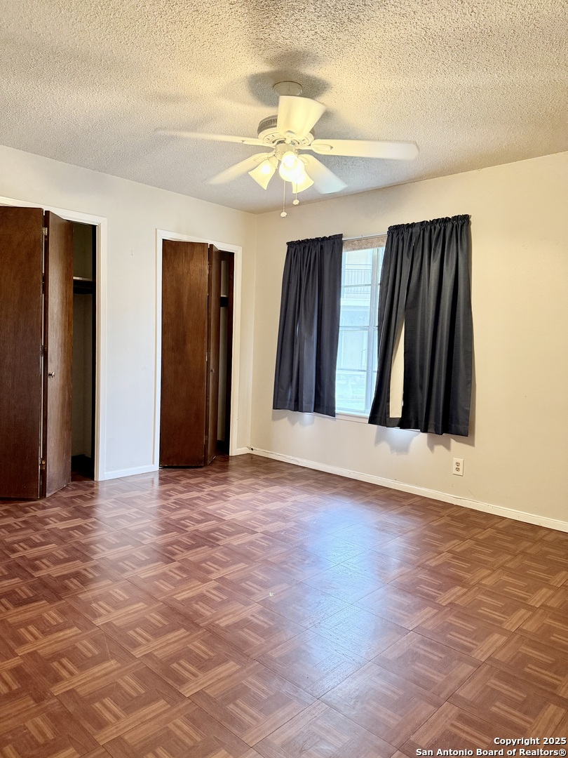 911 Vance Jackson Road, Unit 104J San Antonio, TX 78201 - Photo 4 of 14 a view of a hallway with wooden floor and a ceiling fan