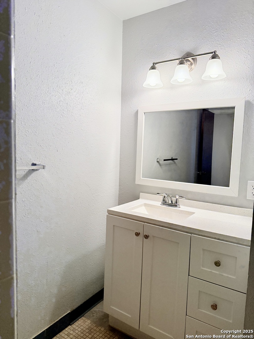 911 Vance Jackson Road, Unit 104J San Antonio, TX 78201 - Photo 6 of 14 a bathroom with a sink and a mirror