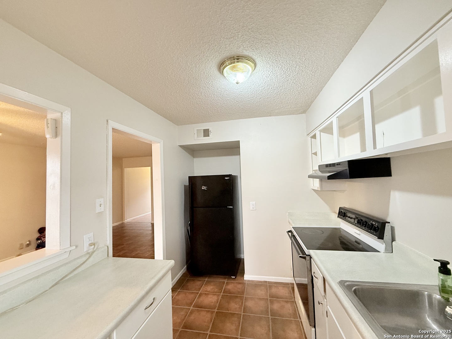 911 Vance Jackson Road, Unit 104J San Antonio, TX 78201 - Photo 10 of 14 a kitchen with a sink and a refrigerator