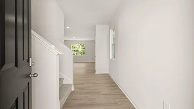 a view of a hallway with wooden floor and staircase