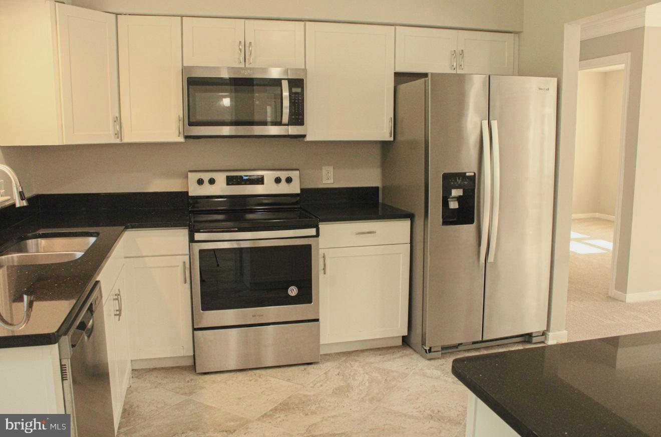 25073 Oxford Road Ruther Glen, VA 22546 - Photo 10 of 37 a kitchen with a stove a microwave and a refrigerator