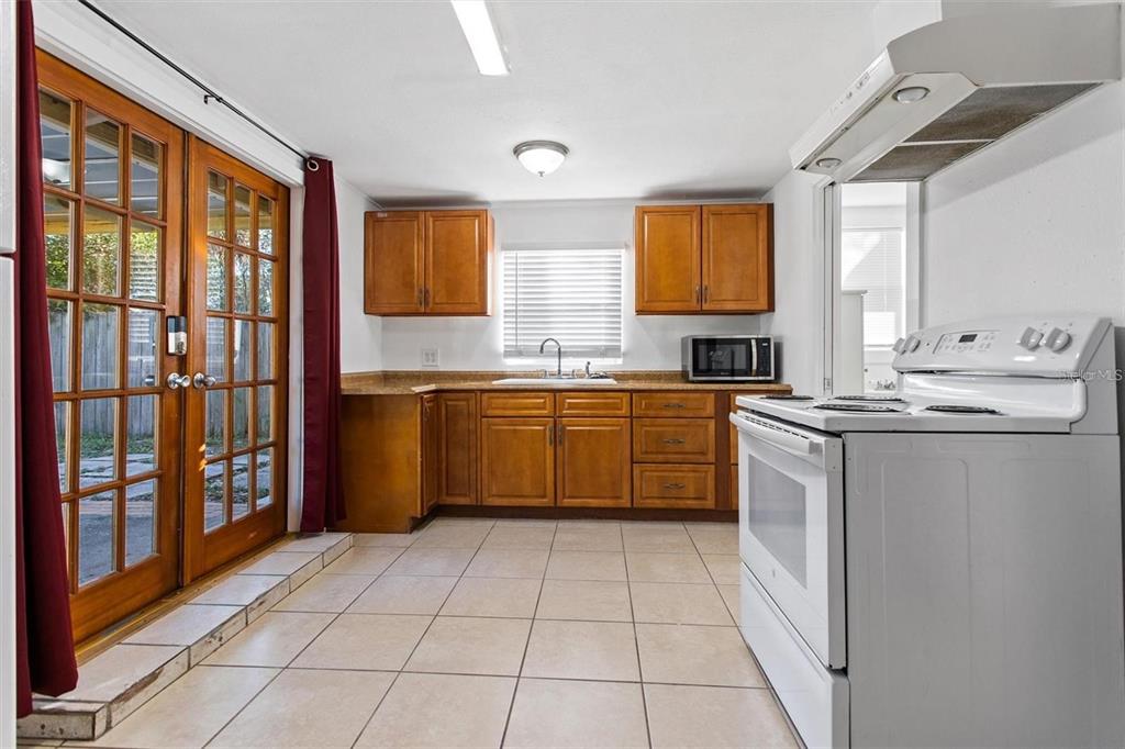 904 Lakeview Road, Unit B Clearwater, FL 33756 - Photo 7 of 19 a kitchen with stainless steel appliances granite countertop a sink counter space cabinets and a large window