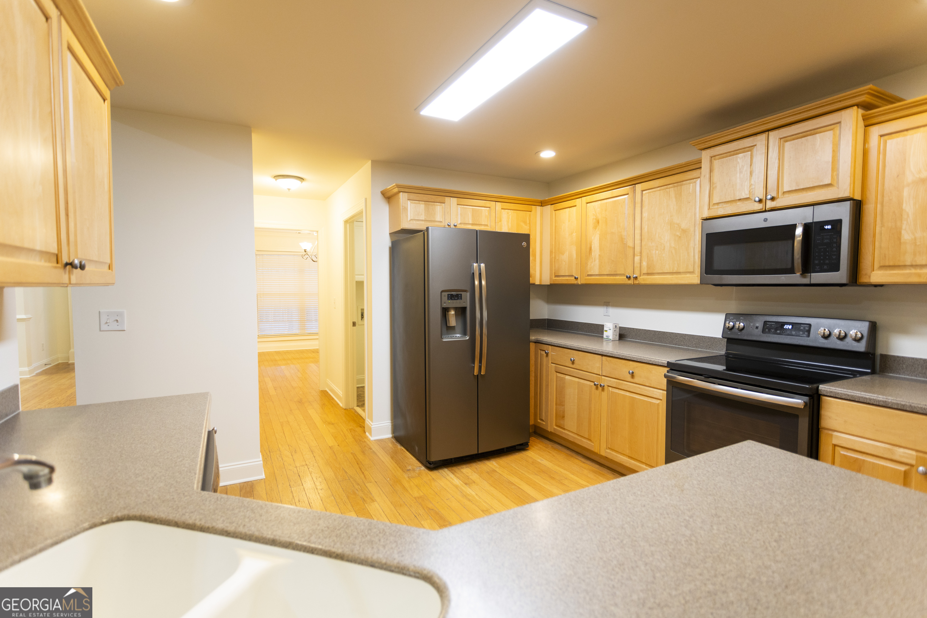 931 Bethany Road Covington, GA 30016 - Photo 35 of 83 a kitchen with stainless steel appliances a refrigerator a stove a sink and a microwave