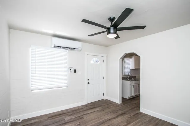 a view of a big room with wooden floor and a ceiling fan