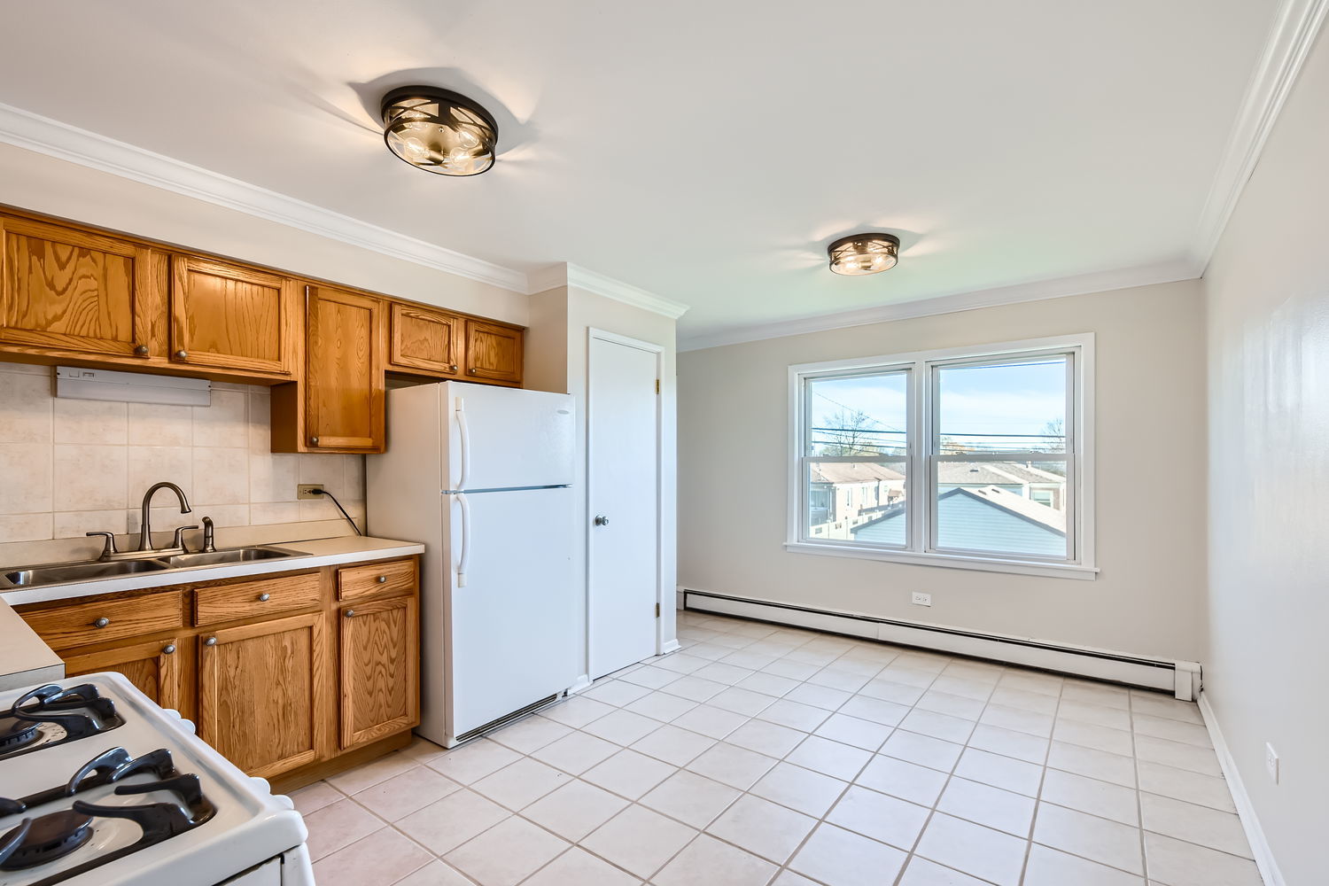 10767 South Pulaski Road, Unit 5 Chicago, IL 60655 - Photo 5 of 10 a kitchen with a sink a stove cabinets and a window