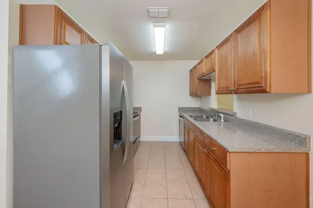 a kitchen with stainless steel appliances granite countertop a refrigerator a sink and a stove