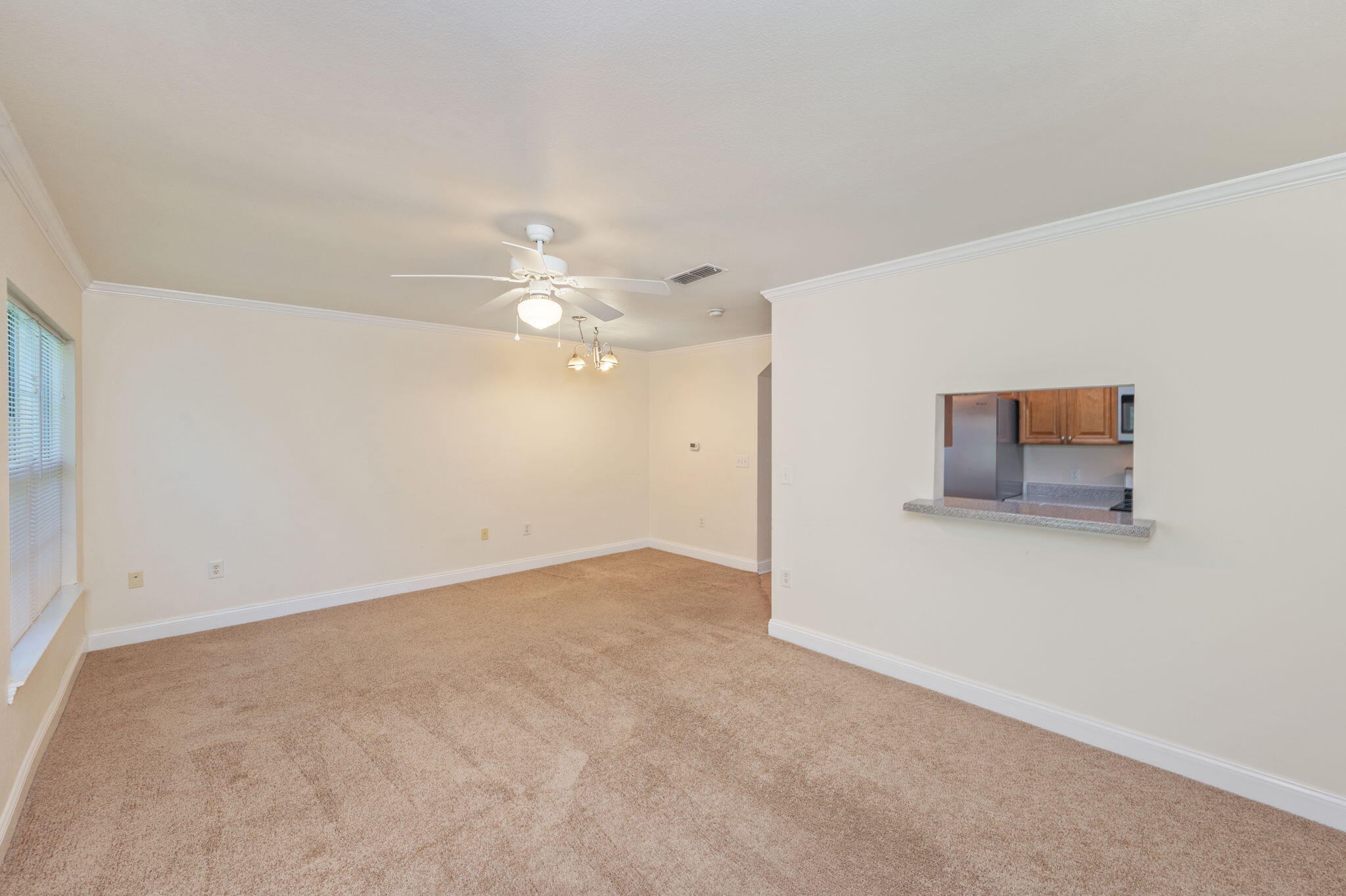 535 Wingspan Way Crestview, FL 32536 - Photo 3 of 26 an empty room with chandelier fan and windows