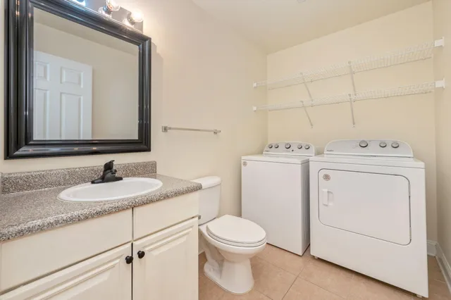 a bathroom with a granite countertop toilet sink and mirror