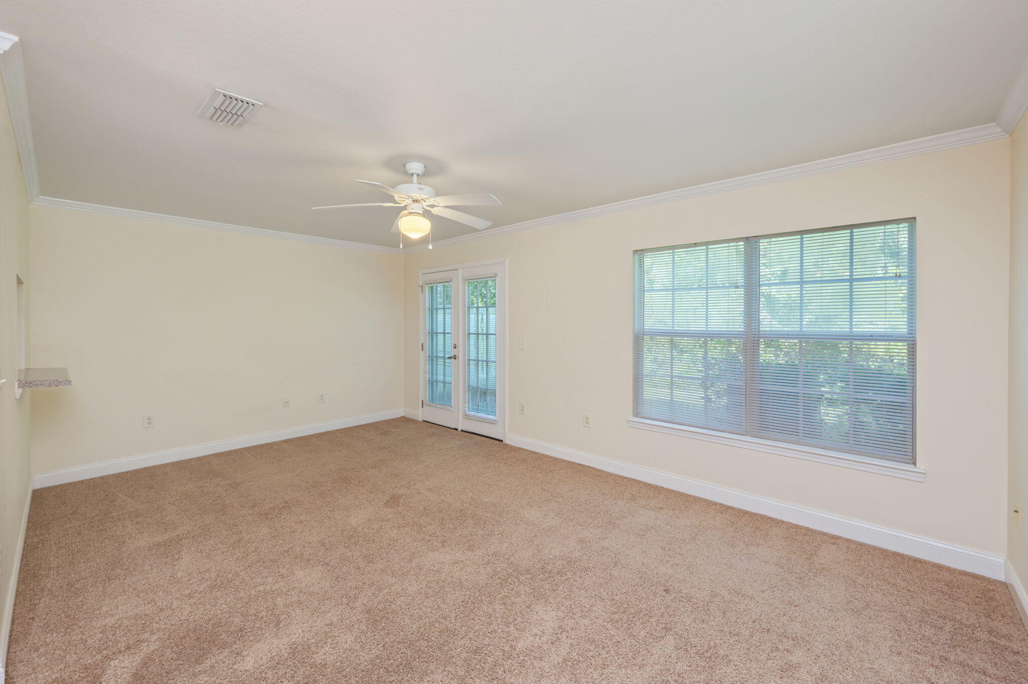 535 Wingspan Way Crestview, FL 32536 - Photo 9 of 26 an empty room with windows and chandelier fan