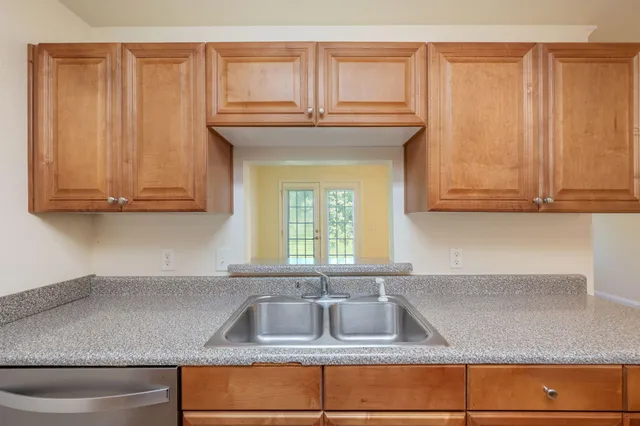 a kitchen with granite countertop white cabinets and a sink