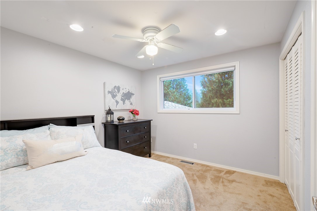 13621 196th Avenue Southeast Renton, WA 98059 - Photo 15 of 31 a bedroom with a large bed and a chandelier