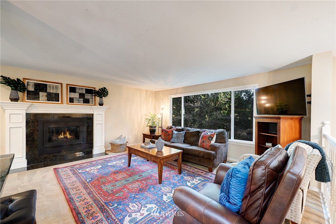 13621 196th Avenue Southeast Renton, WA 98059 - Photo 4 of 31 a living room with furniture a fireplace and a flat screen tv