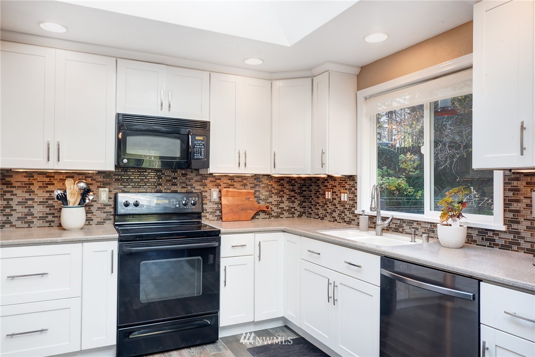 13621 196th Avenue Southeast Renton, WA 98059 - Photo 8 of 31 a kitchen with white cabinets appliances a sink and a window