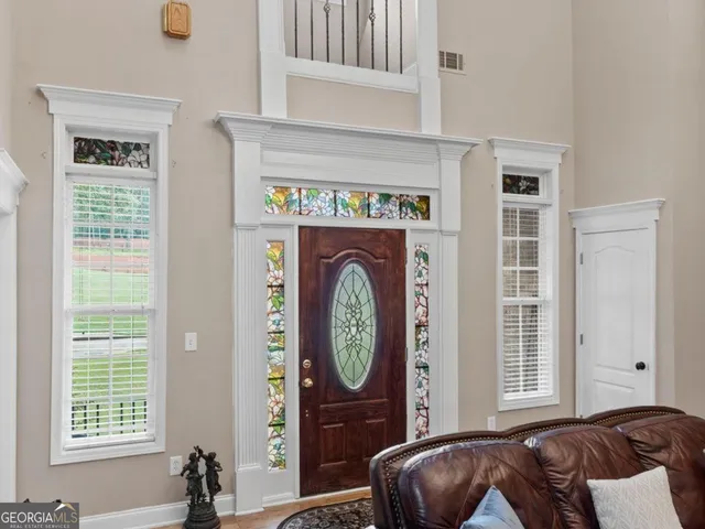 a bedroom with a bed dresser and a large window