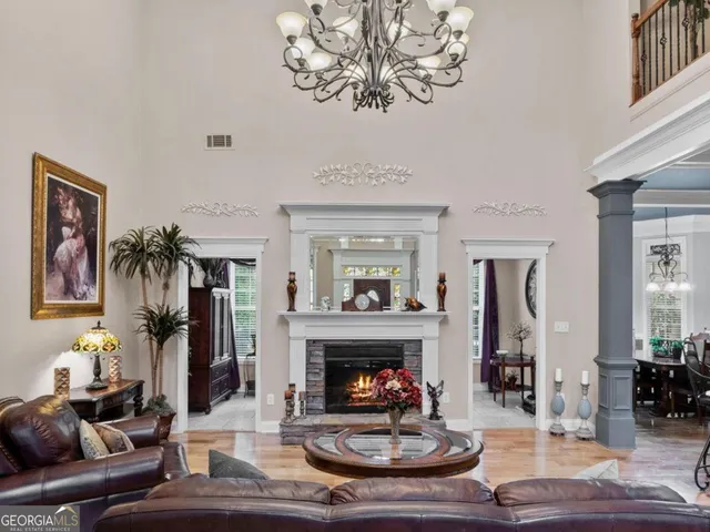a living room with furniture kitchen view and a chandelier