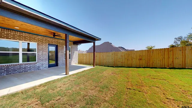 a view of backyard with wooden fence