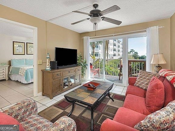 1440 Ocean Boulevard, Unit 119 St. Simons, GA 31522 - Photo 2 of 15 a living room with furniture a flat screen tv and a floor to ceiling window