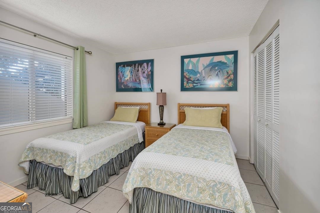 1440 Ocean Boulevard, Unit 119 St. Simons, GA 31522 - Photo 8 of 15 a bedroom with two beds and a large window