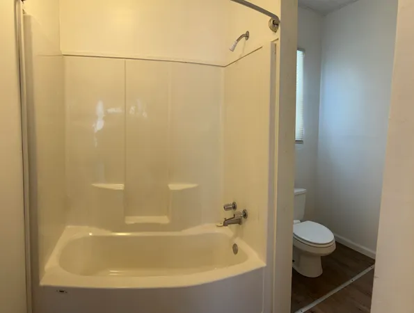 a white bath tub sitting next to a toilet