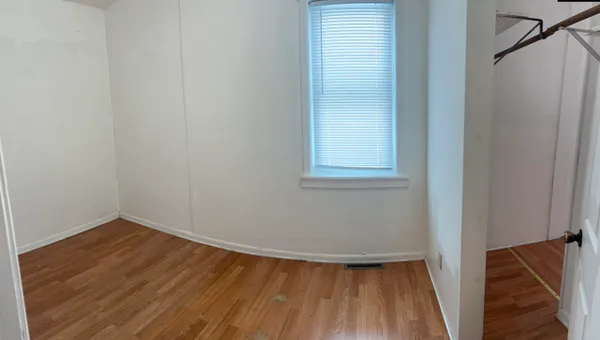 a view of a small space with wooden floor and a window