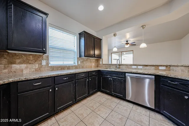 a kitchen with stainless steel appliances granite countertop wooden cabinets a stove top oven a sink and dishwasher