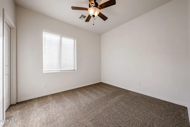 a view of an empty room with a ceiling fan