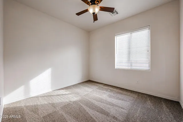 a view of an empty room with a ceiling fan