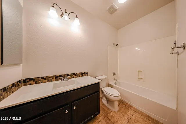 an empty room with windows and chandelier fan