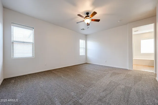a view of an empty room with a chandelier fan