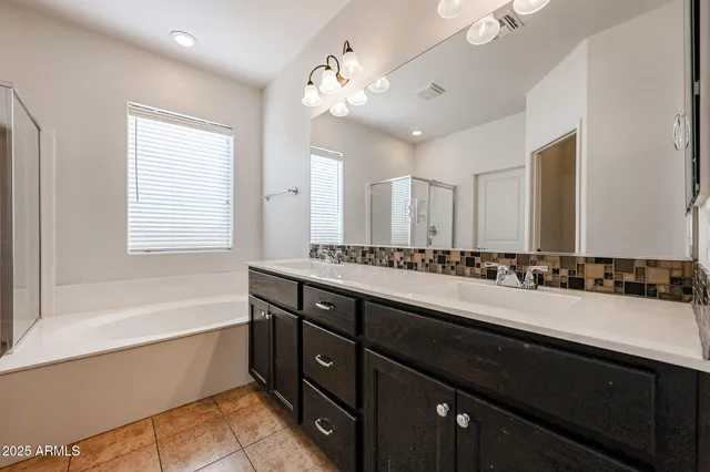 a bathroom with a tub sink and mirror