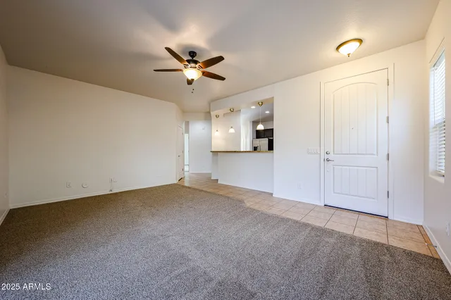 an empty room with windows and ceiling fan