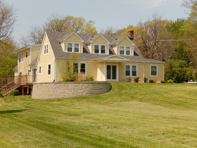 a view of a large pool with a lawn chairs under an umbrella