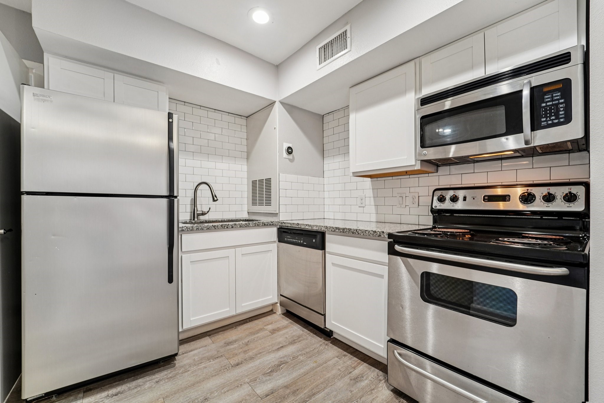 a kitchen with a refrigerator stove and microwave