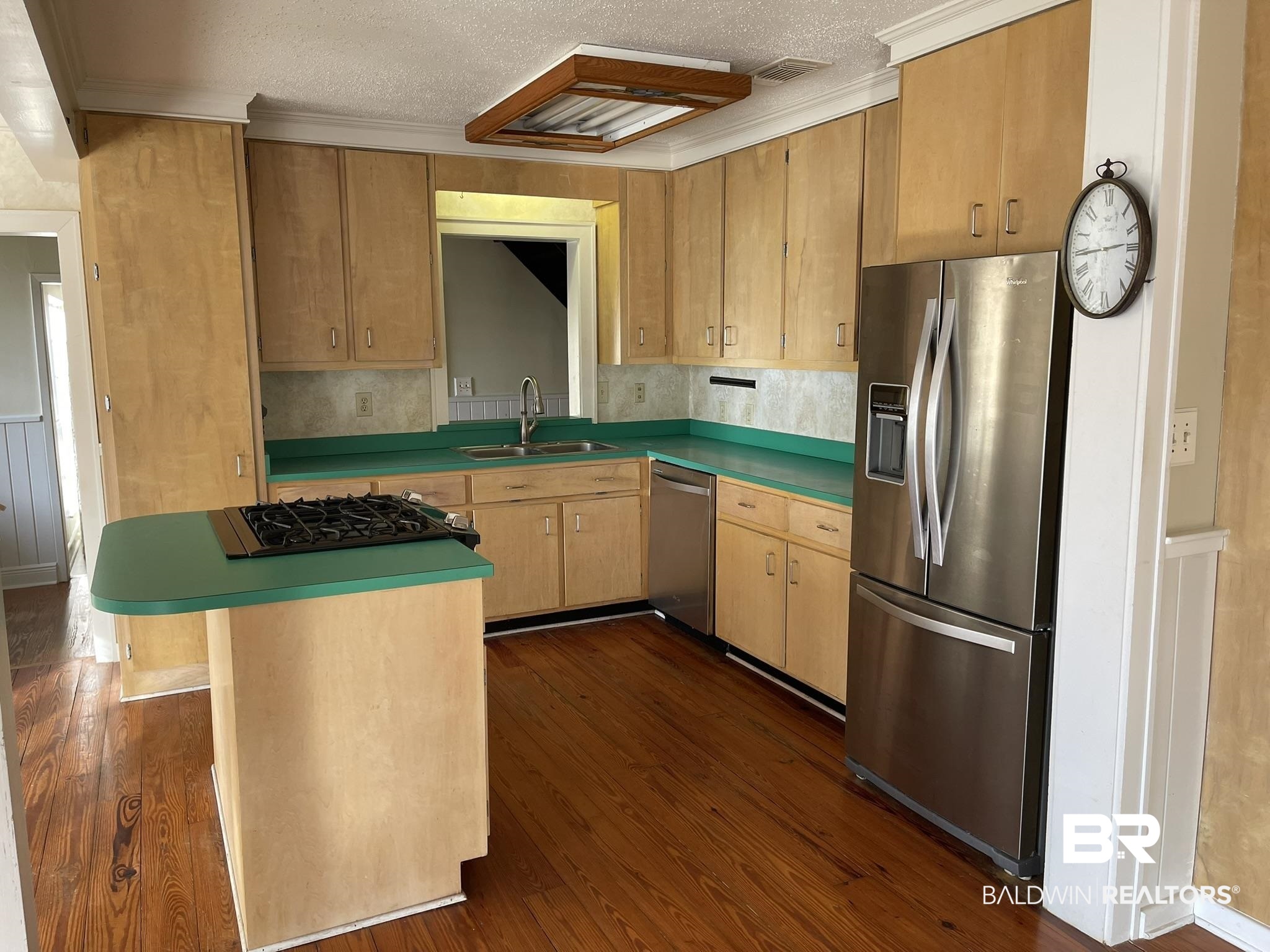 6621 Purvis Road Daphne, AL 36527 - Photo 20 of 59 Kitchen with a textured ceiling, stainless steel appliances, a center island, dark wood finished floors, and crown molding