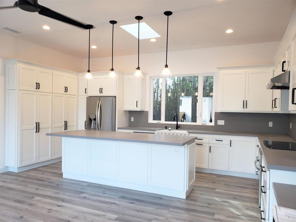 804-814 Clark Avenue Encinitas, CA 92024 - Photo 3 of 18 a large kitchen with stainless steel appliances kitchen island a large island a oven a sink and a wooden floors