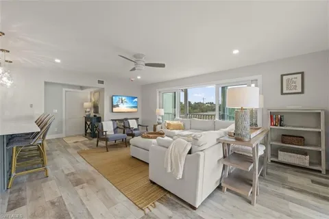 a living room with furniture a large window and a table