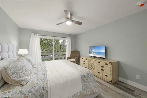 a large bedroom with a bed and wooden floor