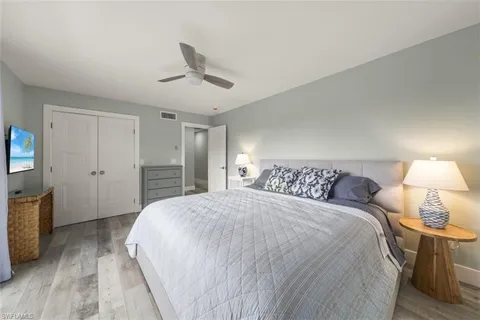 a spacious bedroom with a bed and a lamp