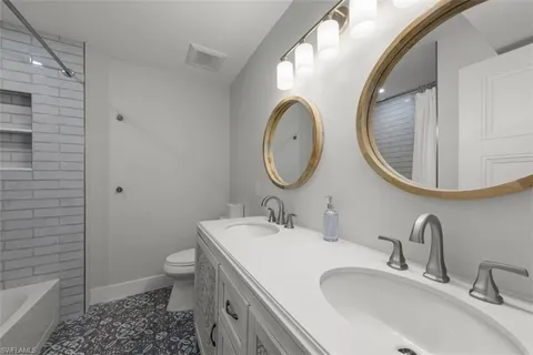 a bathroom with a granite countertop toilet a sink and a mirror