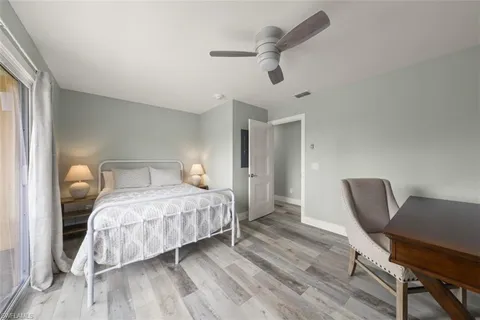 a bedroom with a bed a chair and a chandelier